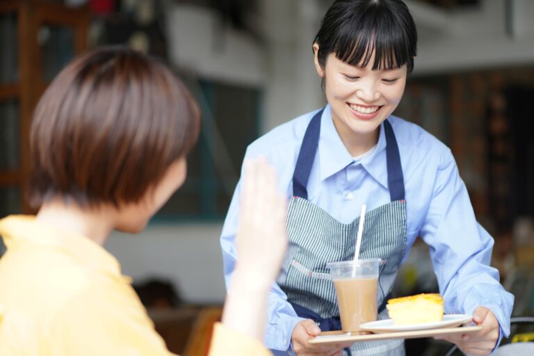 カフェでデザートを提供する女性店員